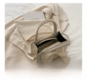 Detail view of large capacity cream white bow bag with leather texture and inner pockets