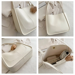 Détails du grand sac cabas crème avec coutures apparentes, charme d'ours et fermoir aimanté