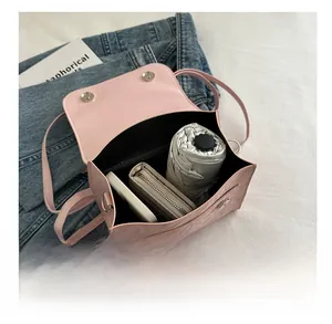 Pink shoulder bag interior showing capacity for phone, wallet and folded umbrella