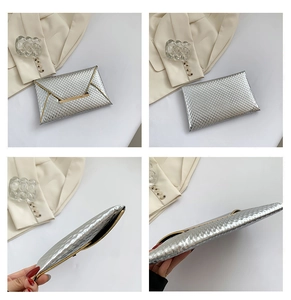 Detailed close-up of a silver textured envelope clutch with elegant gold metal trim