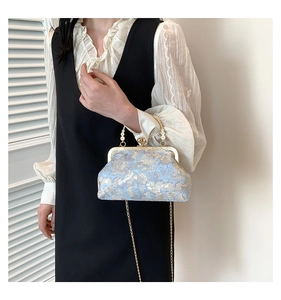 Dettaglio borsa a mano vintage in broccato azzurro con chiusura dorata e perle