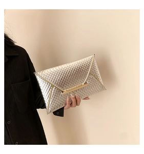 Macro detail of glossy silver envelope clutch with luxury honeycomb embossed texture