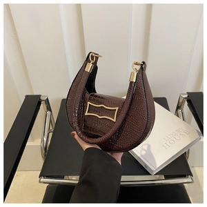 Close-up of brown crocodile pattern hobo bag with vintage gold buckle and handle