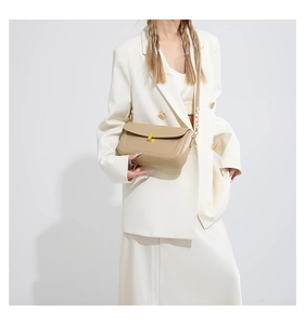 Chic beige PU leather crossbody bag with gold metal buckle on white suit model
