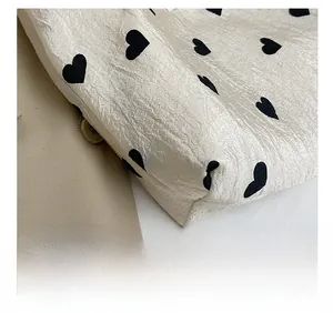 Detailed view of precision stitching and textured heart pattern on canvas tote bag