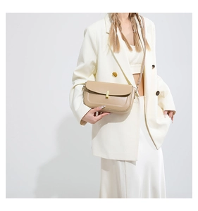 Detail of minimalist beige PU leather crossbody bag featuring a gold rectangular metal lock