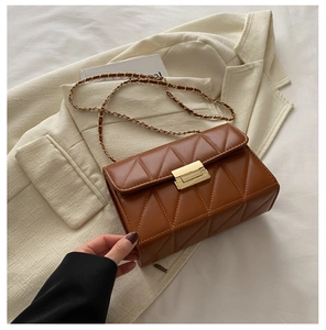 Detailed view of brown quilted shoulder bag with gold clasp and chain strap