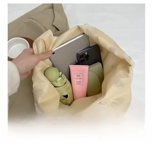 Spacious interior of canvas tote bag holding a tablet, phone, umbrella, and accessories