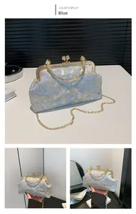 Detail of vintage blue brocade floral crossbody bag with gold metal frame and kiss lock