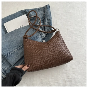 Detail of a brown woven hobo shoulder bag with a fine texture on a clean white background