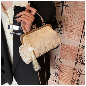 Detailed view of floral embroidery on a vintage silk evening bag with tassels