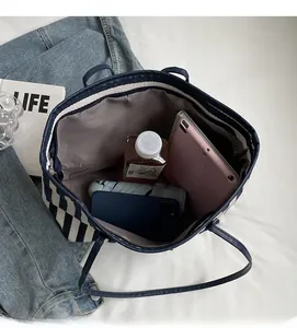 Interior view showing large capacity and compartments of striped canvas tote bag