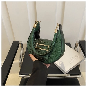 Close-up of green crocodile-embossed crescent handbag with elegant gold metal hardware