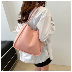 Sac seau rose en cuir avec coutures en U et fines bandoulières porté par un mannequin