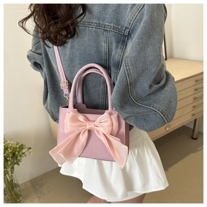 Detail showing the large organza bow and premium leather texture of the pink crossbody bag