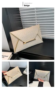 Detail of beige envelope clutch bag with scale texture and gold metal trim finish