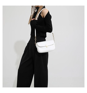 Chic white leather shoulder bag with gold chain strap on black outfit for model display