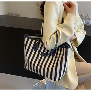 Close-up of blue and white striped tote bag showing durable canvas texture and handles