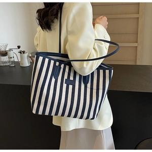 Gros plan d'un sac cabas en toile à rayures bleues et blanches au style décontracté