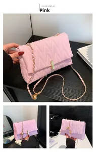 Close-up of pink pleated shoulder bag with M-pattern stitching and gold chain strap