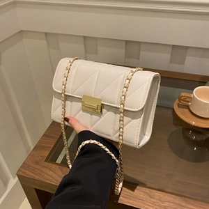 Elegant white quilted crossbody bag with V-shaped stitching and gold chain strap