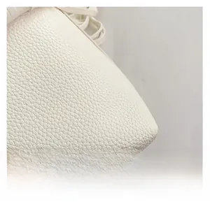 Macro shot of high-quality white lychee grain leather texture with soft glossy finish