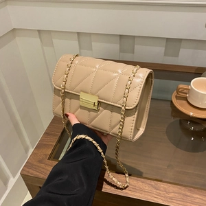 Elegant beige quilted crossbody bag with gold chain strap and metallic clasp closure