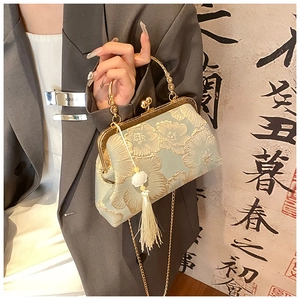 Detailed embroidery on light green silk evening bag with elegant golden round handle
