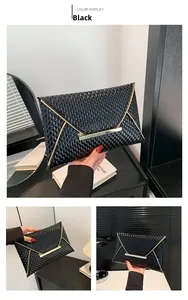Detail of black patent envelope clutch bag featuring glossy textured finish and gold trim