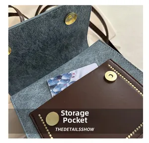 Detail of internal storage pocket with brown leather finish and magnetic gold buckle