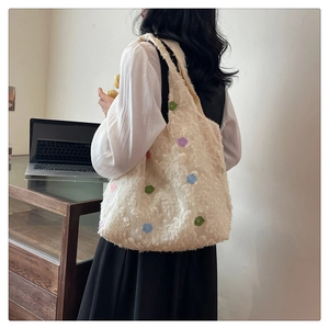 Close-up of white floral tote bag showing colorful 3D flower textures and soft plush fabric