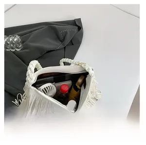 Top view of large white tote bag showing spacious interior with daily essentials and tassels