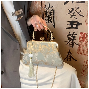 Detail of vintage floral embroidery on satin handbag with pearl tassel and gold chain