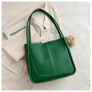 Détail du sac cabas vert foncé avec couture en U et charmant petit ours en peluche brun