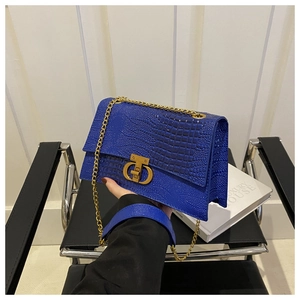 Dettaglio della borsa blu a coccodrillo con chiusura CD dorata e tracolla a catena