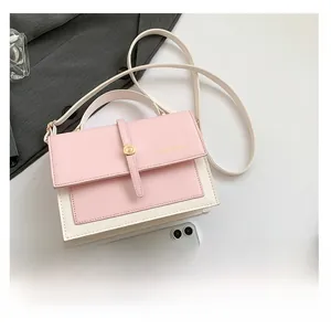 Close-up of pink and white contrast flap bag with golden buckle and fashion logo text