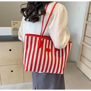 Vue détaillée latérale d'un sac cabas en toile rayé rouge et blanc avec bandoulière rouge