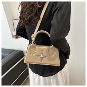 Borsa a tracolla beige in pelle con dettaglio stella argento su una modella elegante