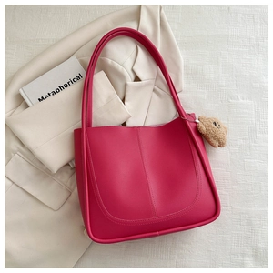 Détail du sac seau fuchsia avec breloque ours en peluche marron et fines bandoulières