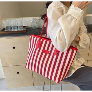 Gros plan d'un sac cabas en toile à rayures verticales rouges et blanches avec sangle