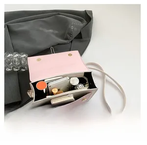 Internal view of pink contrast crossbody bag showing capacity for phone and makeup