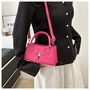 Dettaglio della mini borsa rosa acceso con stella e tracolla rimovibile su una modella