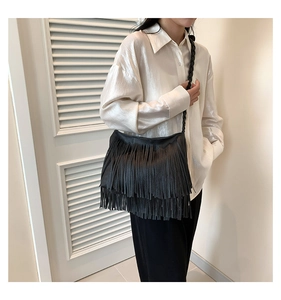 Détail d'un sac à bandoulière noir à franges avec bandoulière tressée et cuir grainé