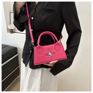 Dettaglio mini borsa magenta con decoro a stella in metallo e tracolla sottile