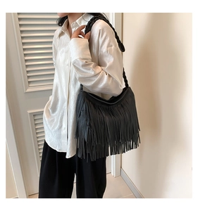 Fashionable black tassel shoulder bag with braided strap shown on a model