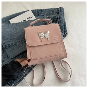 Détail du mini sac à dos rose en similicuir froissé avec boucle papillon argentée