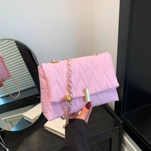 Chic pink quilted shoulder bag with golden chain and metallic ball detail in hand
