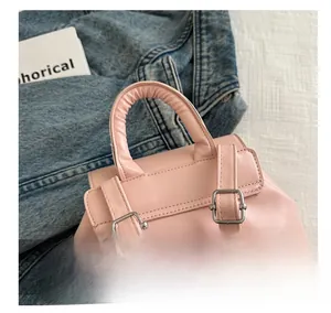 Detail of pink bow backpack featuring a round top handle and silver buckle straps
