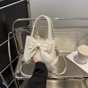 Minimalist beige handbag with large silk bow decoration and detachable shoulder strap