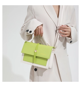 Détail du sac bandoulière vert citron et blanc cassé avec boucle ronde dorée